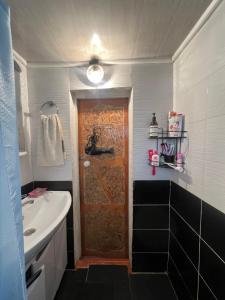 a bathroom with a sink and a wooden door at Azamat in Kara-Koo