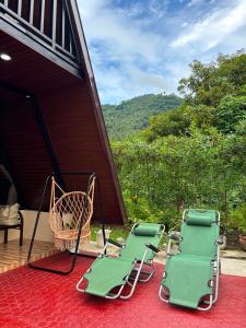 two lawn chairs sitting on the porch of a house at Casa Carmelita in Batangas City +9 photos