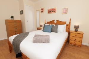 ein Schlafzimmer mit einem großen weißen Bett mit hölzernem Kopfteil in der Unterkunft Millbrae, Shetland Islands in Lerwick