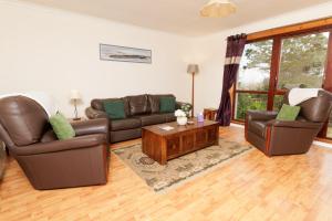 ein Wohnzimmer mit zwei Sofas und einem Couchtisch in der Unterkunft Millbrae, Shetland Islands in Lerwick