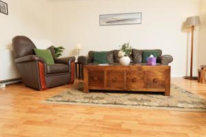 ein Wohnzimmer mit zwei Sesseln und einem Couchtisch in der Unterkunft Millbrae, Shetland Islands in Lerwick