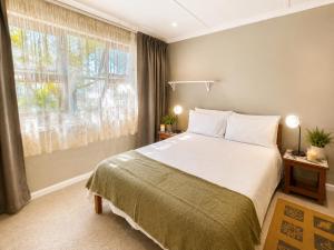 a bedroom with a bed and a large window at Sandy Fingers Apartment in Plettenberg Bay +13 photos