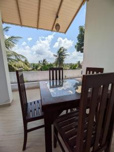 a table and chairs on a balcony with a view at Casa Luna Home Stay in Dickwella