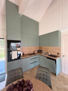 a kitchen with a sink and a table with chairs at Meža māja in Ģipka +7 photos
