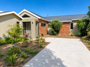 a brick house with a walkway in front of it at Sandy Fingers Apartment in Plettenberg Bay