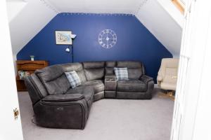 a living room with a couch and a blue wall at North Harbour View, Shetland Islands in Lerwick