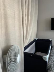 a black crib with a fan next to a curtain at Le cocon-Romania in Châteauroux