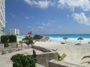 una playa de arena con sombrillas y el océano en Apartment Cancun, en Cancún