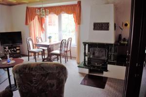 a living room with a fireplace and a table and chairs at Ferienwohnung Am oberen Hexenstieg in Altenbrak