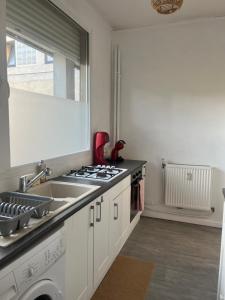 a kitchen with a sink and a stove top oven at Le cocon-Romania in Châteauroux