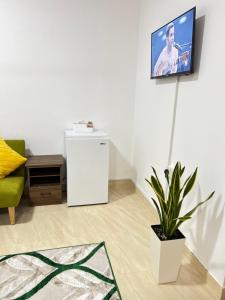 a living room with a refrigerator and a tv on the wall at Waterfront vip master room in Muscat