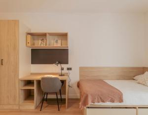 a bedroom with a desk and a bed and a desk and a chair at micampus Logroño Centro in Logroño
