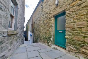 an alley with a blue door in a stone building at Mowbray's Nook, Shetland Islands in Lerwick