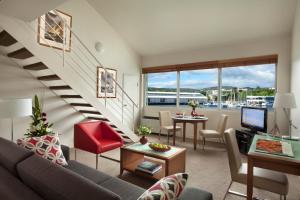 a living room with a staircase with a couch and a table at Somerset on the Pier Hobart in Hobart