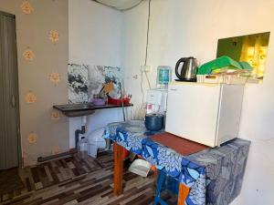a kitchen with a table and a refrigerator at Dahlia Roomstay Jelai in Gemas