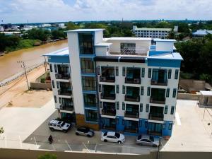 an apartment building with cars parked in front of it at The Viewpoint Hotel in Ban Wat Tha Maprang