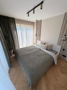a bedroom with a large bed with a large window at Meža māja in Ģipka