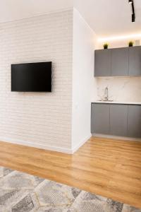 a kitchen with a tv on a white brick wall at ЖК "Женис III" in Kokshetau