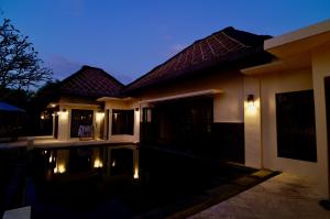 a house with a swimming pool at night at Starsand Beach Resort in Sekotong