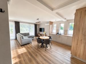 a living room with a table and chairs and a couch at Apartamenty Lipowa in Puck