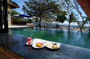 a tray of food on a table next to a swimming pool at Starsand Beach Resort in Sekotong