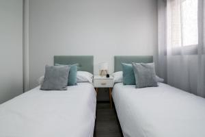 two beds sitting next to each other in a bedroom at Getafe Suites in Getafe