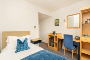 a hotel room with a bed and a desk and a chair at The Rodney Hotel in Bristol