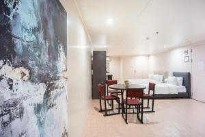 a room with a bed and a table and chairs at Green Sun Hotel in Manila