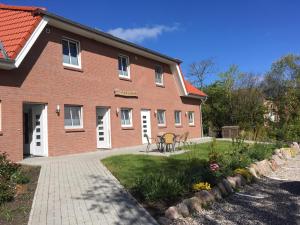 a brick building with a table and chairs in front of it at Dörpshus im strandnahen Bojendorf in Fehmarn