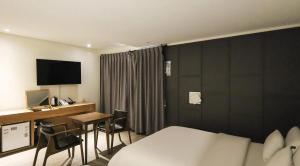 a hotel room with a bed and a desk with a computer at cs프라자호텔 in Cheonan