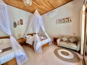 a bedroom with two beds with mosquito nets at AVYANA sanctuary in Gobleg