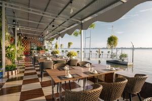 a restaurant with tables and chairs next to the water at Van Phat Riverside Hotel in Can Tho