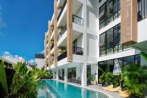 an exterior view of a building with a swimming pool at Sunny Aparts 1 by Betterplace in Canggu