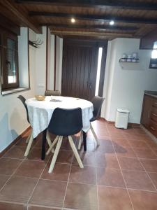 a dining room with a white table and chairs at La casa de Somiedo in Pola de Somiedo