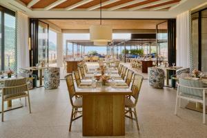 a dining room with a long table and chairs at Falkensteiner Resort Lake Garda in Salò