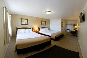 A bed or beds in a room at Sunset Lodge Escanaba