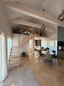 a living room with a loft bed and a table at Meža māja in Ģipka