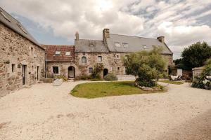 an old stone building with a tree in the yard at Clos des sentiles in Perros-Guirec