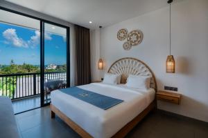 a bedroom with a large bed and a balcony at Sunny Aparts 1 by Betterplace in Canggu