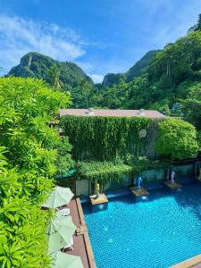 an overhead view of a swimming pool with trees and umbrellas at Phi Phi Maiyada Resort in Phi Phi Islands