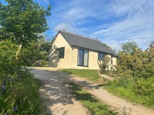 a small white house on a dirt road at The Quarry Caravan in Falmouth