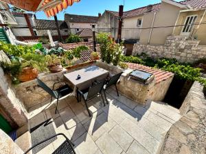 a patio with a table and chairs in a backyard at Apartment Dalmatera in Rogoznica