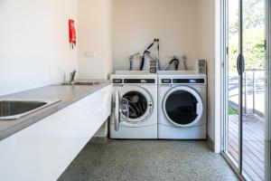 a kitchen with a washing machine and a sink at Geelong Holiday Park in Geelong
