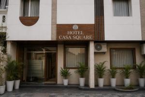 a hotel casa square with potted plants in front of it at Hotel Casa Square in Indore +1 photo