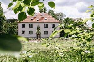 a white house with a red roof in a field at Bytovka1962 in Manětín