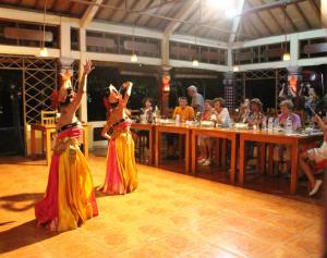 two women in skirts dancing on the floor in a restaurant at Lovina Beach Hotel in Lovina