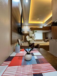 a living room with a table with a vase on it at Cozy Modern Loft Studio in Cubao in Manila