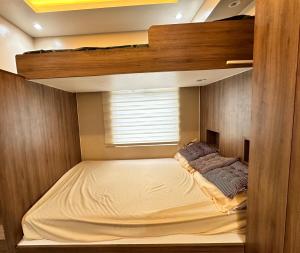 a bunk bed in a room with a window at Cozy Modern Loft Studio in Cubao in Manila
