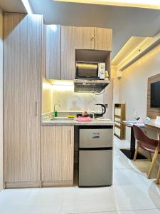 a kitchen with a sink and a microwave at Cozy Modern Loft Studio in Cubao in Manila