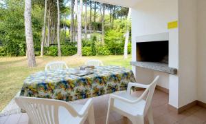 a table and chairs in a patio with a fireplace at Villaggio Paradiso in Bibione
